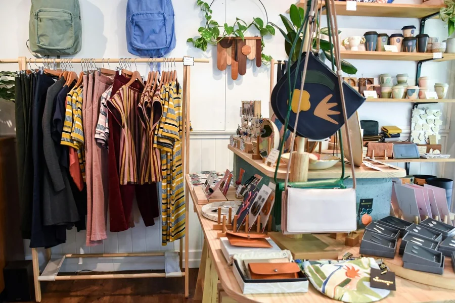 Interior de un pequeño comercio con ropa, bolsos y cerámica expuestos